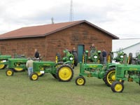 A display of John Deere two-cylinder tractors.