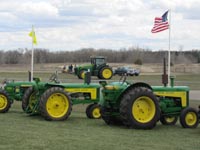 Old and new John Deere tractors on display at the entrance.
