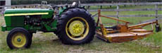 rotary mower mounted behind a tractor