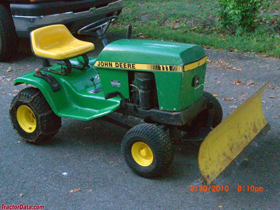 John Deere 111H with front-mount blade and tire chains.