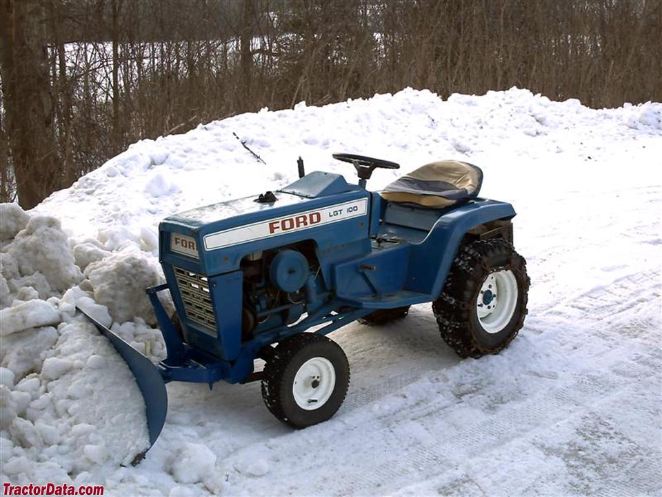 Ford LGT-100 plowing snow with front-mounted blade.