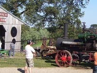 A steam engine powers the pioneer saw mill.