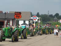John Deere tractors lined for the parade through the Little Log House Pioneer Village.