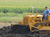 >Caterpillar D4D bulldozer pushing dirt.