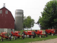 Allis-Chalmers tractors lined in front of the 1913 dairy barn.