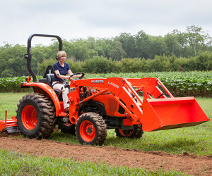 Kubota L2501 tractor with front-end loader and tiller.