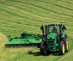 John Deere 6R tractor mowing hay